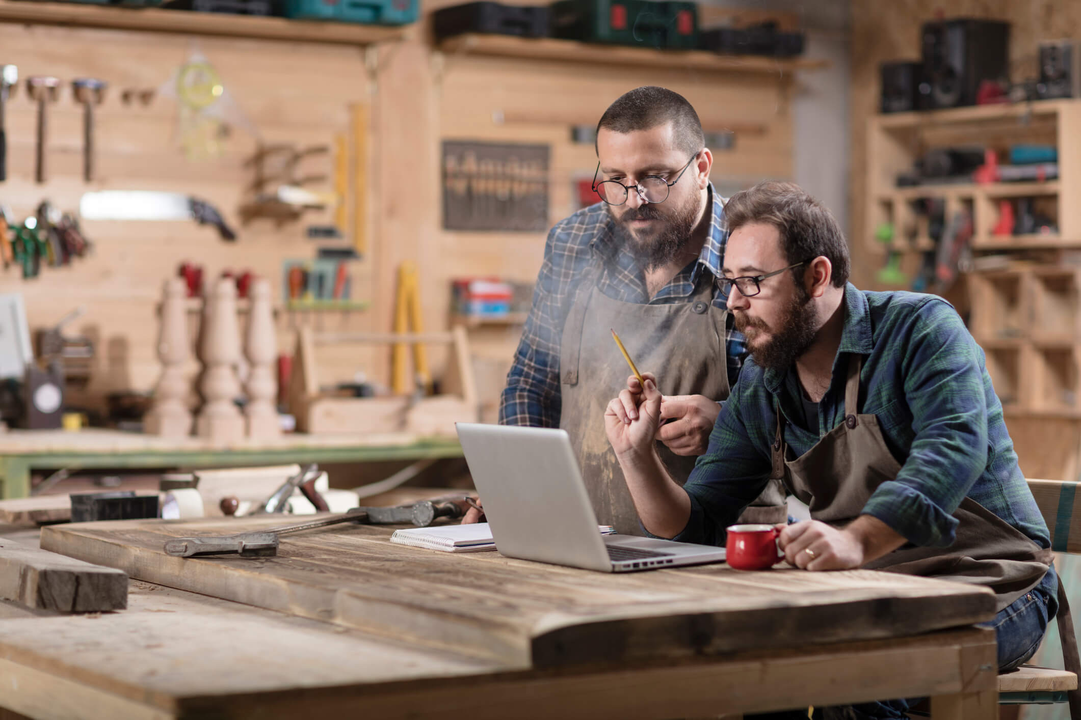two people working together on laptop in wood working workshop