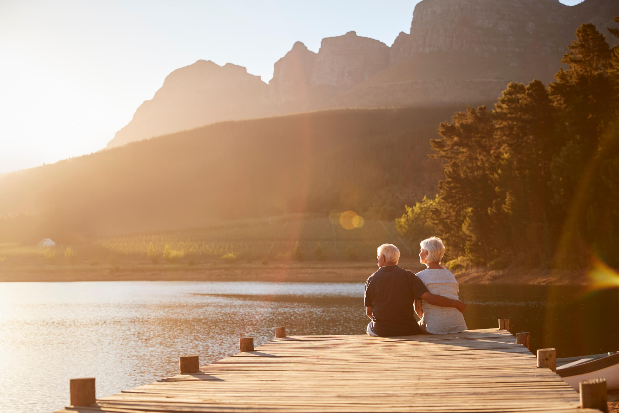 couple sitting together on end of wooden dock